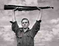 marine holding rifle over his head
