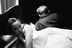 man and woman in bed, turned away from each other