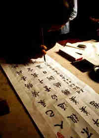 man writing chinese caligraphy