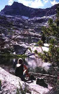 seated person looking across lake in high sierras