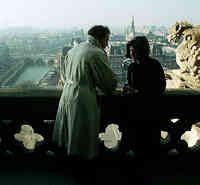 couple talking on balcony overlooking a city